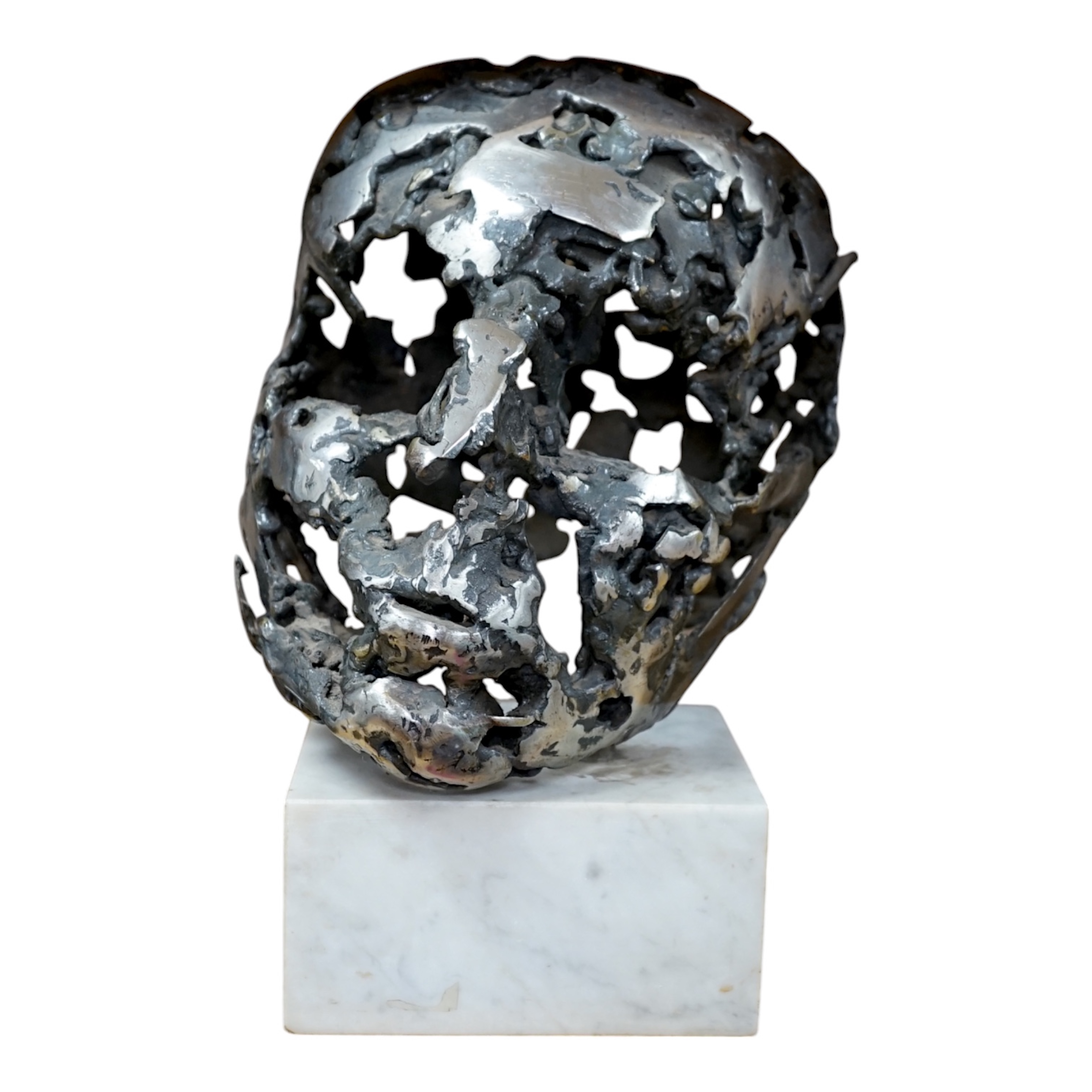 A modern polished steel skull, pierced and mounted on square white marble plinth, circa 1975, 31cm high. Condition - good, minor chipping